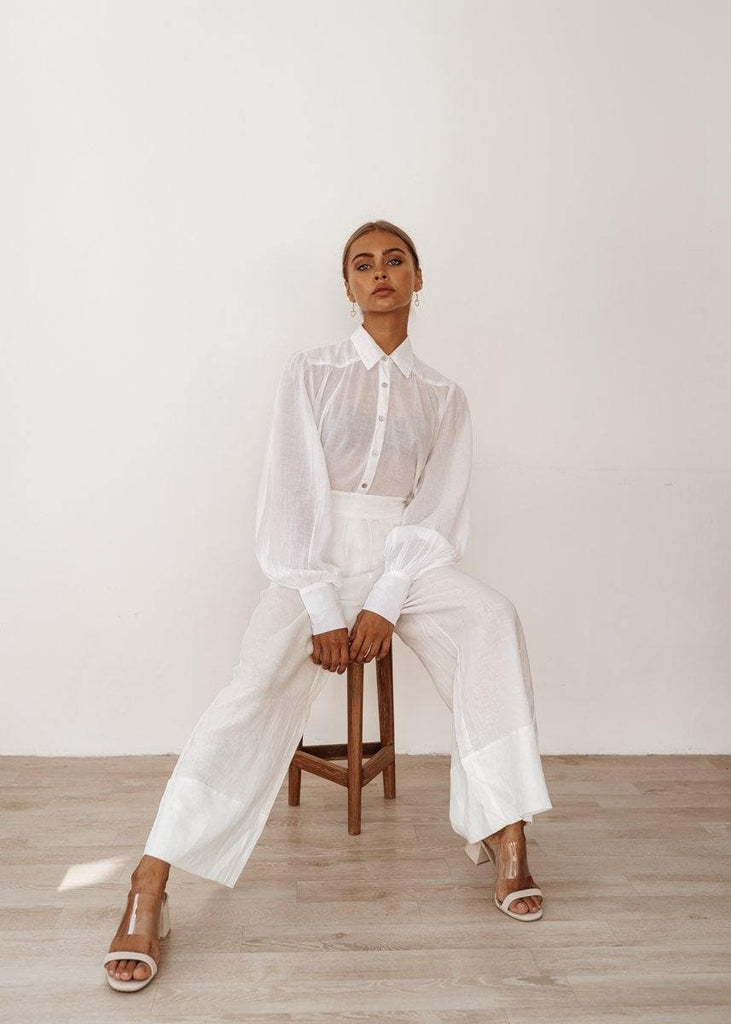 model in a gorgeous linen shirt is sitting on a chair